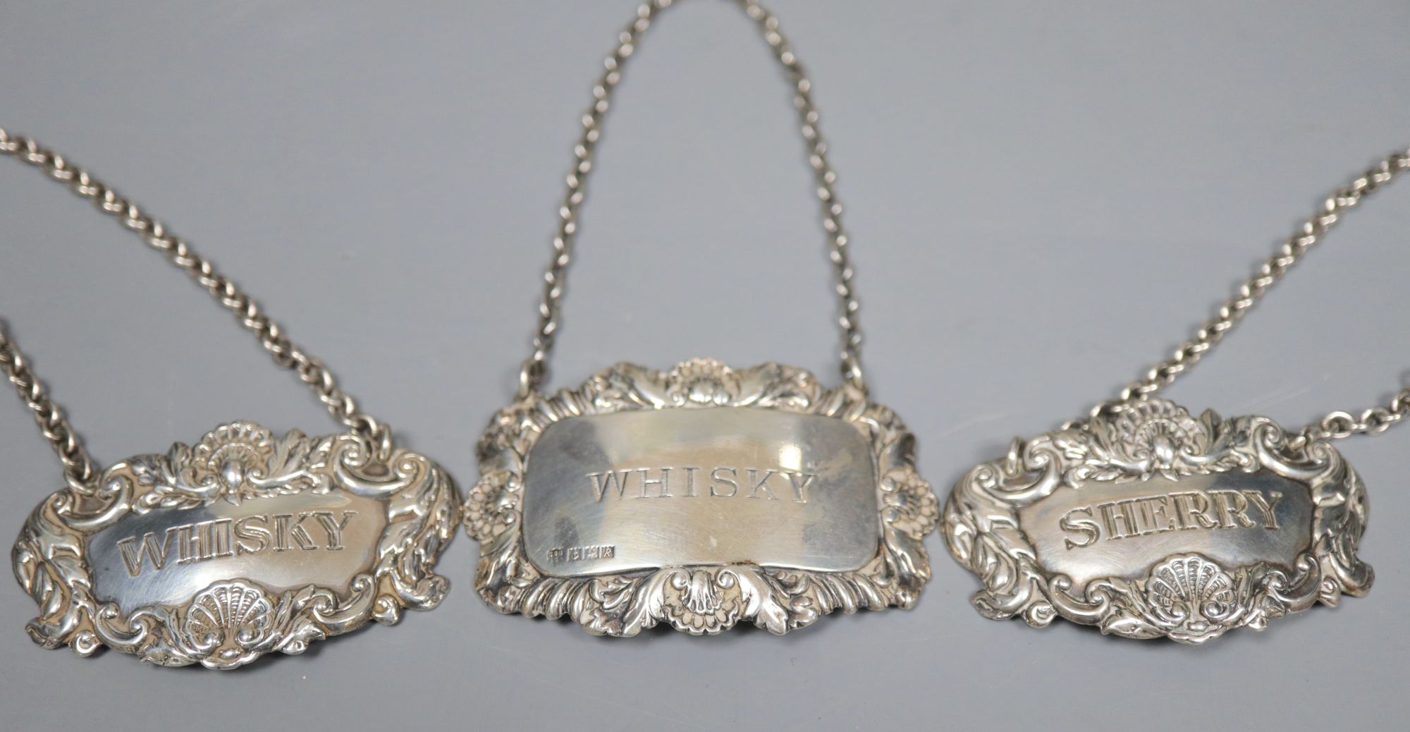 A collection of small silver to include a cased set of six coffee spoons and tongs, three wine labels and a pair of grape scissors